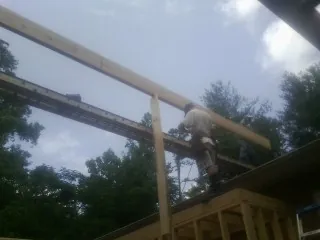 Carpenter setting a ridge beam over a new addition frame — Ice Dam Removal by Roofing Brothers in Muncy