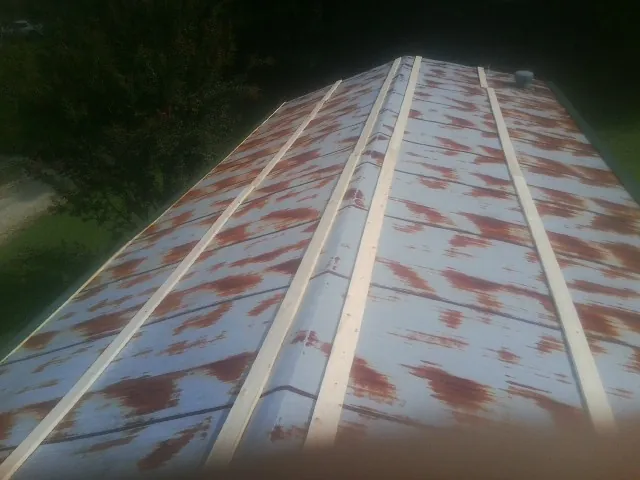 Rusted metal roof panels with new wood purlins before replacement — Storm Damage Roof Repair in Muncy by Roofing Brothers