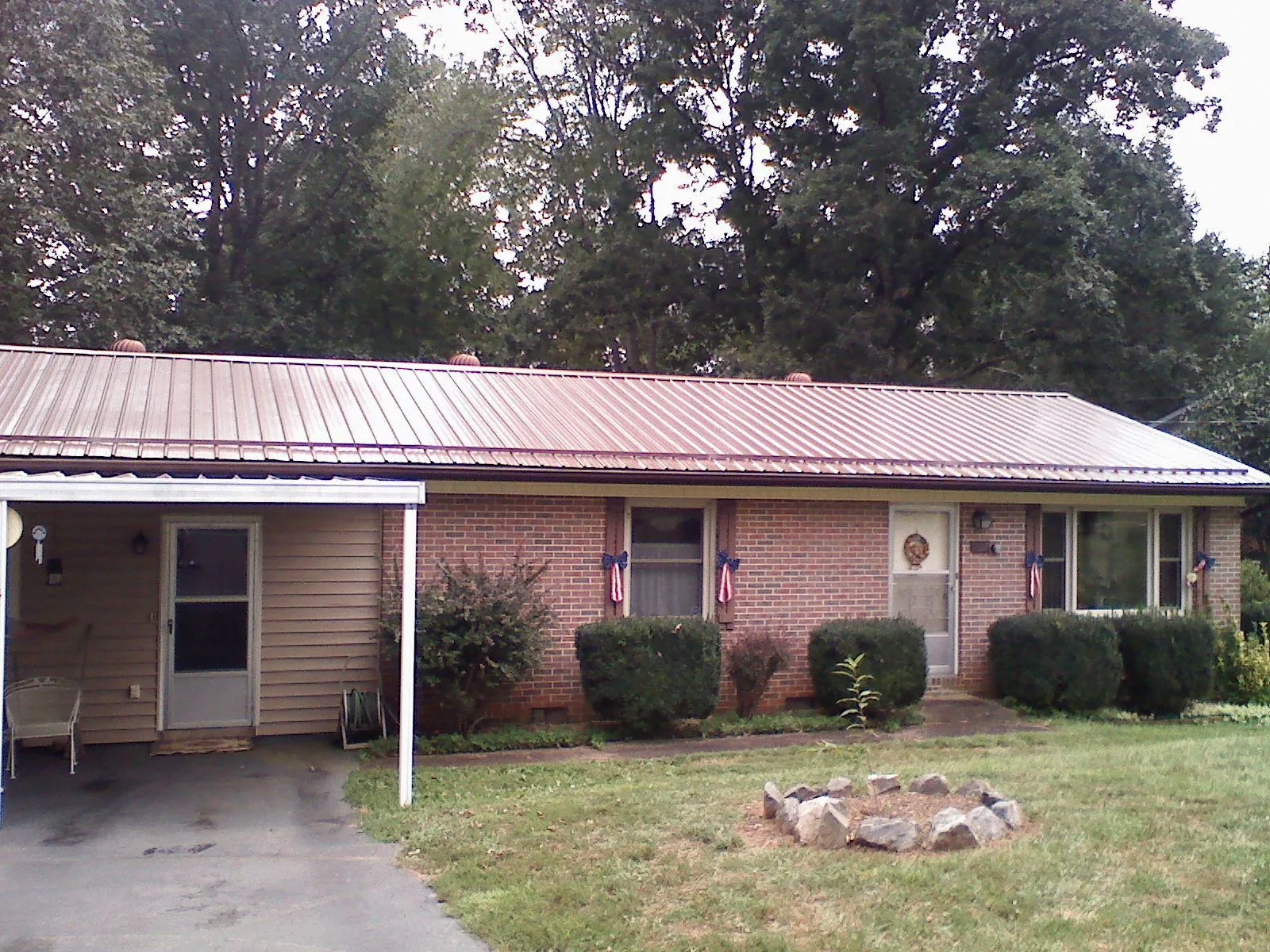 Bronze metal roof and carport on a brick ranch home — Roof Repair work by our crew in Muncy